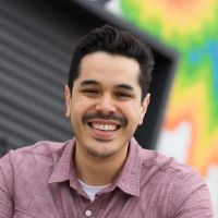 Portrait of Anthony Gardés infront of a colorful wall